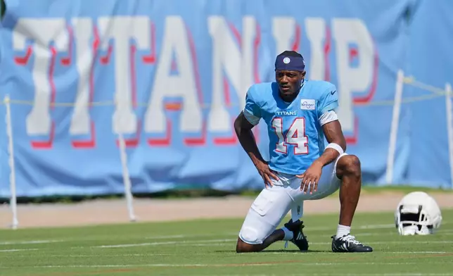 Tennessee Titans wide receiver Carnell Tate (14) stretches during the NFL football team's training camp Tuesday, Aug. 25, 2026, in Nashville, Tenn. (AP Photo/George Walker IV)