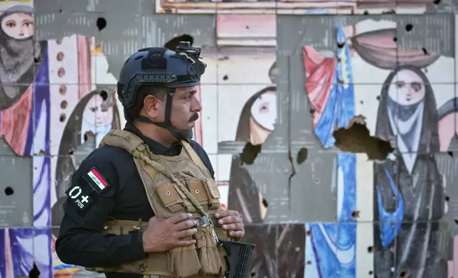 An Iraqi security officer stands guard at the site near Baghdad International Airport where Iranian military commander Qassem Soleimani was killed in a U.S. drone strike, during a visit by Iranian Parliament Speaker Mohammad Baqer Qalibaf in Baghdad, Iraq, Wednesday, Aug. 19, 2026. (AP Photo/Hadi Mizban)