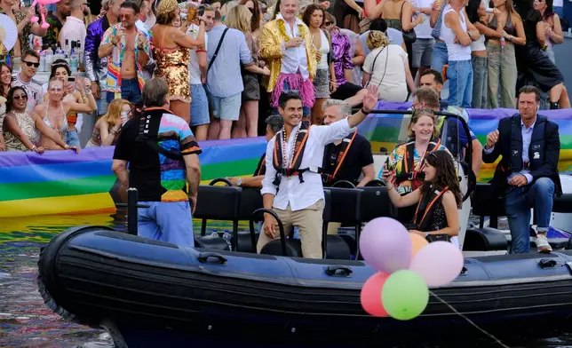 Netherland's Prime Minister Rob Jetten, center, waves as he rides on a boat, Saturday, Aug. 1, 2026, during the Canal Parade, the most popular event of the Pride Amsterdam festival that attracts tens of thousands of visitors to the city. (AP Photo/Patrick Post)
