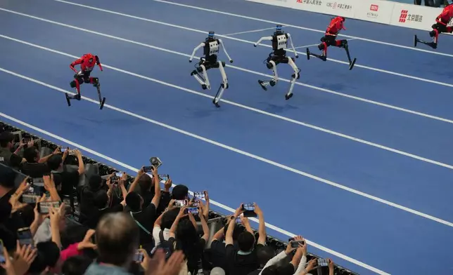 Humanoid robots compete in the 100 meter race during the World Humanoid Robot Games in Beijing, Wednesday, Aug. 26, 2026. (AP Photo/Achmad Ibrahim)