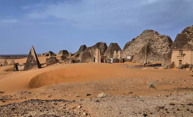 A visitor walks among the Meroe pyramids at the Meroe archaeological site in Bejrawiya, Sudan, Saturday, Aug. 1, 2026. (AP Photo/Mohnd Blal)