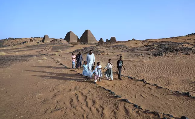 A family visits the Meroe pyramids at the Meroe archaeological site in Bejrawiya, Sudan, Friday, July 31, 2026. (AP Photo/Mohnd Blal)
