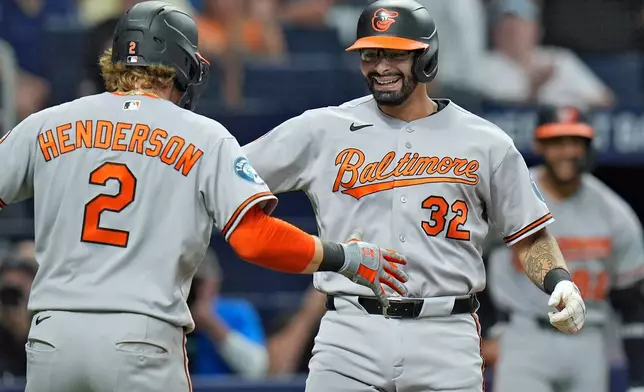 Baltimore Orioles' Christian Encarnacion-Strand (32) celebrates his two-run home run off Tampa Bay Rays pitcher Tyler Wells with Gunnar Henderson (2) during the fifth inning of a baseball game Monday, Aug. 17, 2026, in St. Petersburg, Fla. (AP Photo/Chris O'Meara)