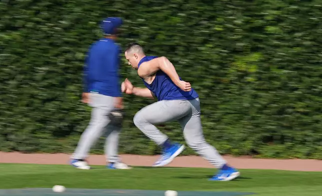 Los Angeles Dodgers pitcher Tarik Skubal, right, runs in the outfield before a baseball game against the Chicago Cubs, Monday, Aug. 3, 2026, in Chicago. (AP Photo/David Banks)