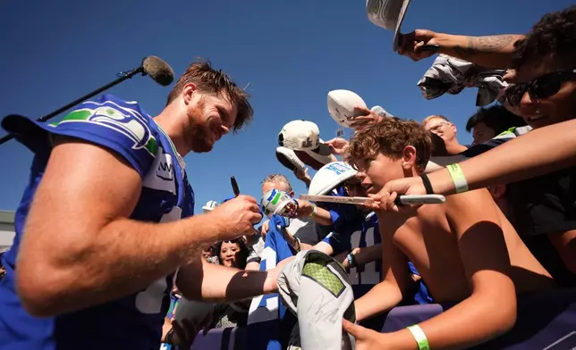 Seattle Seahawks quarterback Sam Darnold signs autographs during the NFL football team's training camp, Saturday, Aug. 1, 2026, in Renton, Wash. (AP Photo/Lindsey Wasson)
