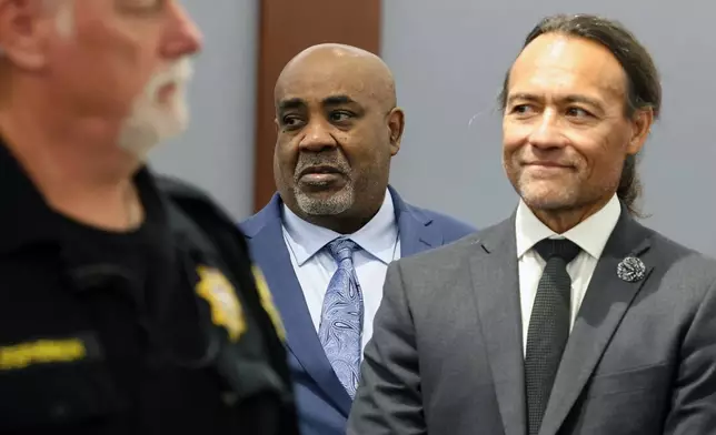 Duane Davis, center, stands with his attorney Michael Sanft, right, as prospective jurors enter the courtroom during the fourth day of jury selection for his murder trial in Clark County District Court at the Regional Justice Center on Thursday, Aug. 13, 2026, in Las Vegas. Davis was indicted on murder charges for his involvement in the killing of rapper Tupac Shakur in 1996. (Bizuayehu Tesfaye/Las Vegas Review-Journal via AP, Pool)