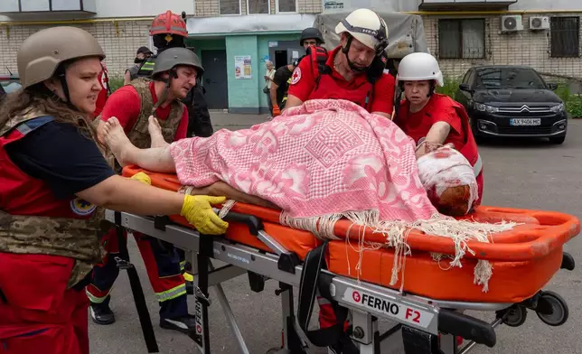 Rescuers evacuate an injured civilian after a residential building was hit following Russia's drone attack in Kharkiv, Ukraine, Sunday, Aug. 9, 2026. (AP Photo/Andrii Marienko)