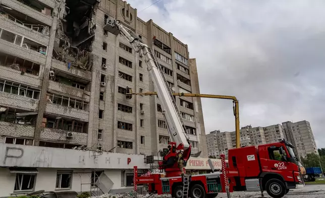 Firefighters put out a fire after a residential building was hit following Russia's drone attack in Kharkiv, Ukraine, Sunday, Aug. 9, 2026. (AP Photo/Andrii Marienko)