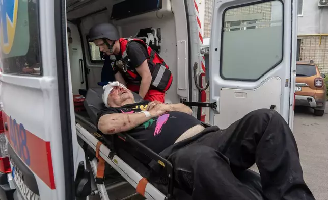 Rescuers evacuate an injured civilian after a residential building was hit following Russia's drone attack in Kharkiv, Ukraine, Sunday, Aug. 9, 2026. (AP Photo/Andrii Marienko)