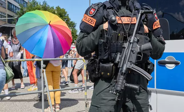 A police officer stands on Steindamm at the edge of Hamburg Pride 2026, the Christopher Street Day (CSD) parade, in Hamburg, Germany, Saturday Aug. 1, 2026. (Georg Wendt/dpa via AP)
