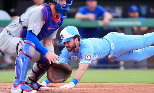 Kansas City Royals' John Rave dives home past Chicago Cubs catcher Carson Kelly to score on a two-run single by Josh Rojas during the second inning of a baseball game Saturday, Aug. 8, 2026, in Kansas City, Mo. (AP Photo/Charlie Riedel)