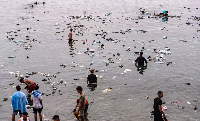 Belongings left behind by migrants float in the sea after they crossed from Morocco into the Spanish enclave of Ceuta, Friday, July 31, 2026. (AP Photo/Antonio Sempere)