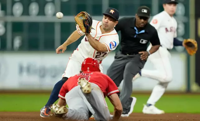 Houston Astros second baseman Jose Altuve (27) catches the throw from catcher Christian Vázquez before tagging out Los Angeles Angels' Josh Lowe as he tries to steal second base during the sixth inning of a baseball game Wednesday, Aug. 19, 2026, in Houston. (AP Photo/David J. Phillip)