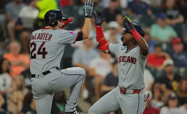 Cleveland Guardians' Angel Martínez, right, celebrates with teammates Chase DeLauter, left, after hitting a grand slam during the fifth inning of a baseball game against the Chicago White Sox, Friday, Aug. 7, 2026, in Chicago. (AP Photo/Melissa Tamez)