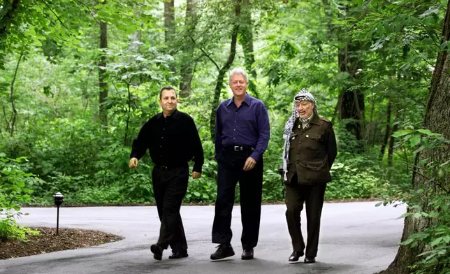 FILE - President Bill Clinton, Israeli Prime Minister Ehud Barak, left, and Palestinian leader Yasser Arafat, right, walk on the grounds of Camp David, Md., Tuesday July 11, 2000, at the start of the Mideast summit. (AP Photo/Ron Edmonds, File)