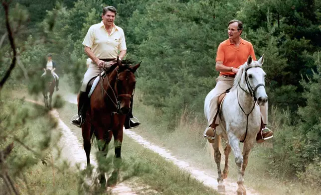 FILE - In this July 1981 file photo released by The White House, U.S. President Ronald Reagan, left, and Vice President George Bush go horseback riding at Camp David, Md. (Michael Evans/The White House, via AP, File)