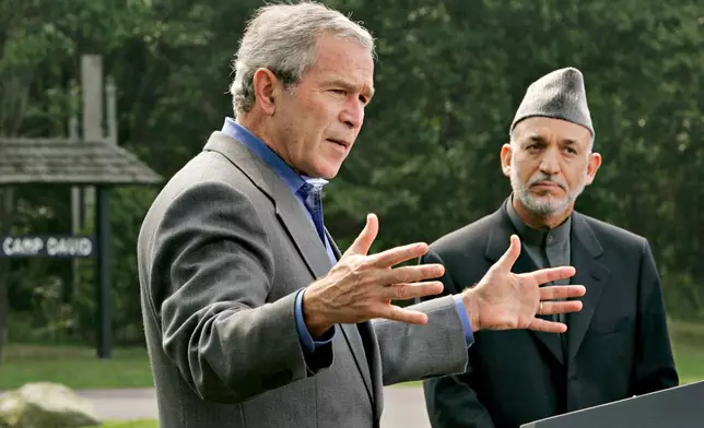 FILE - President George W. Bush, left, accompanied by Afghanistan's President Hamid Karzai, right, gestures during their joint press conference, Monday, Aug. 6, 2007, at Camp David, Md. (AP Photo/J. Scott Applewhite, File)