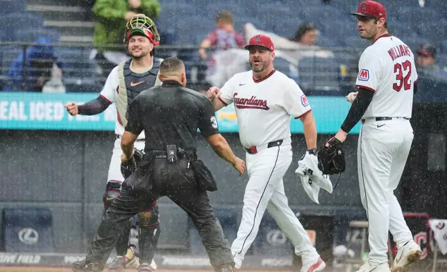 Home plate umpire Jonathan Parra (30) holds back Cleveland Guardians manager Stephen Vogt, center, between catcher Patrick Bailey, left, and pitcher Gavin Williams (32) during an argument in the sixth inning of a baseball game in Cleveland, Sunday, Aug. 2, 2026. (AP Photo/Sue Ogrocki)