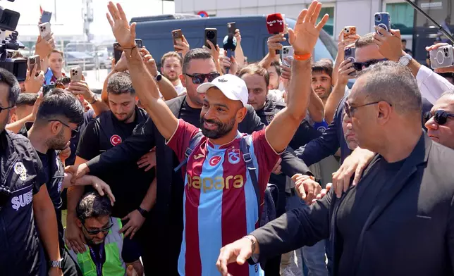 Egypt's Mohamed Salah wearing his new Trabzonspor team jersey gestures to supporters as he arrives at the airport in Istanbul, Turkey, Wednesday, Aug. 5, 2026. (Samet Yalcin/DIA Photo via AP)
