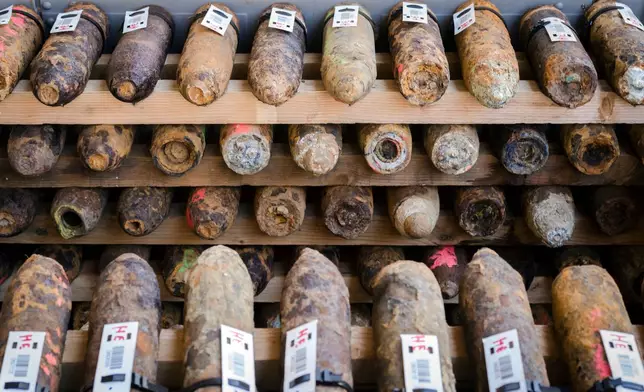 FILE - World War I shells, some marked in pink are suspect gas shells, are piled in a warehouse at the explosive disposal facility (DOVO) in Poelkapelle, Belgium, April 21, 2015. (AP Photo/Geert Vanden Wijngaert, File)