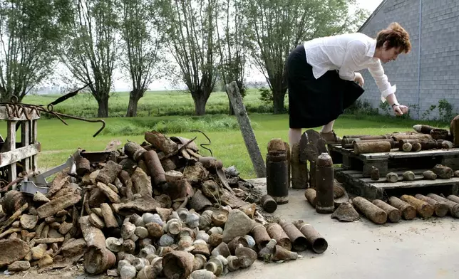 FILE - Charlotte Cardoen-Descamps points out different types of World War I shells that were found on her farm in Poelkapelle, Belgium, May 4, 2007, in what is known as the "iron harvest". (AP Photo/Virginia Mayo, File)