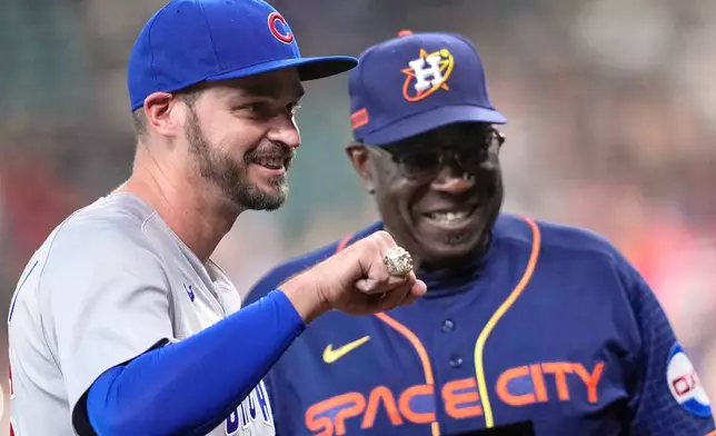 FILE - Chicago Cubs first baseman Trey Mancini, left, holds up his World Series Championship ring after it was presented to him by Houston Astros manager Dusty Baker Jr., before a baseball game, May 15, 2023, in Houston. (AP Photo/David J. Phillip, File)