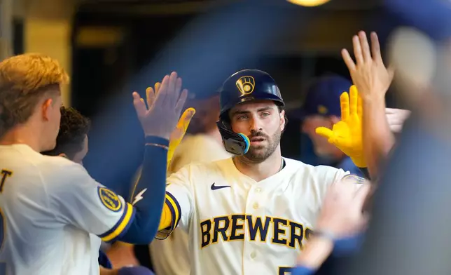 Milwaukee Brewers' Garrett Mitchell high-fives teammates after scoring on an RBI single hit by Andrew Vaughn during the sixth inning of a baseball game against the Pittsburgh Pirates Thursday, Aug. 6, 2026, in Milwaukee. (AP Photo/Kayla Wolf)