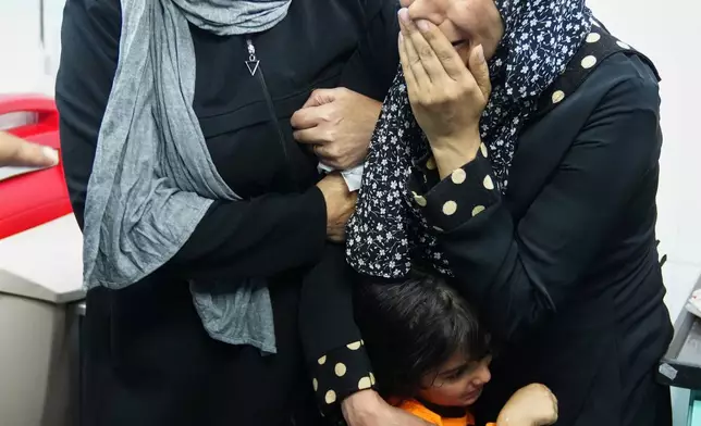 Relatives of killed Palestinian Karim Shalaldeh, 17, cry after his body was transferred to a hospital in the West Bank city of Hebron, Friday, Aug. 21, 2026. (AP Photo/Mahmoud Illean)