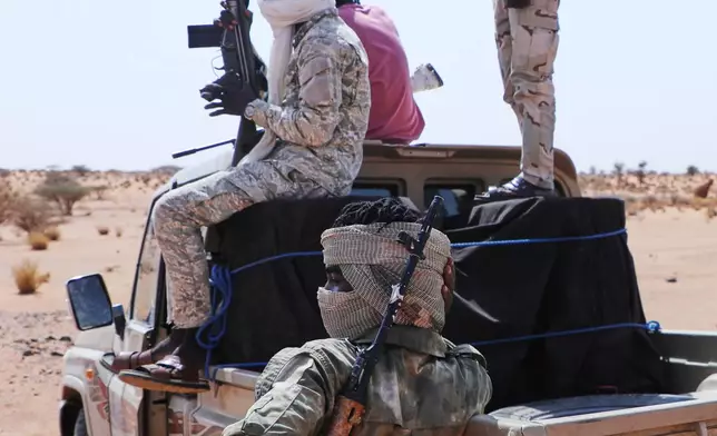 Fighters of armed defectors from the paramilitary Rapid Support Forces (RSF) raise their machine guns, as they are believed to be surrendering to the Sudanese army, in the west of Omdurman, just outside Khartoum, Sudan, Wednesday, Aug. 19, 2026. (AP Photo/Mohnd Blal)
