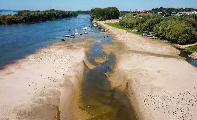 FILE - A usually submerged patch of land rises from the surface of the Danube River due to low levels of the water following an extended period of drought in Corabia, Romania, July 29, 2026. (AP Photo/ Nicolae Dumitrache, File)