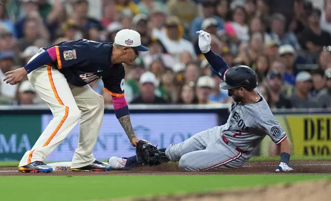 Minnesota Twins' Kody Clemens, arrives safely to third base after hitting a two-RBI triple as San Diego Padres third baseman Manny Machado is late with the tag during the fourth inning of a baseball game Friday, Aug. 21, 2026, in San Diego. (AP Photo/Gregory Bull)