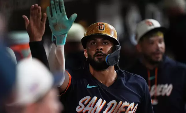 San Diego Padres' Fernando Tatis Jr. celebrates with teammates after scoring off an RBI single by Manny Machado during the fifth inning of a baseball game against the Minnesota Twins Friday, Aug. 21, 2026, in San Diego. (AP Photo/Gregory Bull)