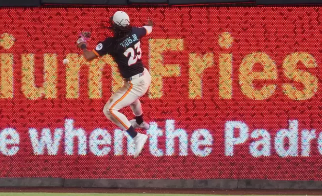 San Diego Padres right fielder Fernando Tatis Jr. leaps off the wall as he is unable to catch a hit for a two-RBI triple by Minnesota Twins' Kody Clemens during the fourth inning of a baseball game Friday, Aug. 21, 2026, in San Diego. (AP Photo/Gregory Bull)