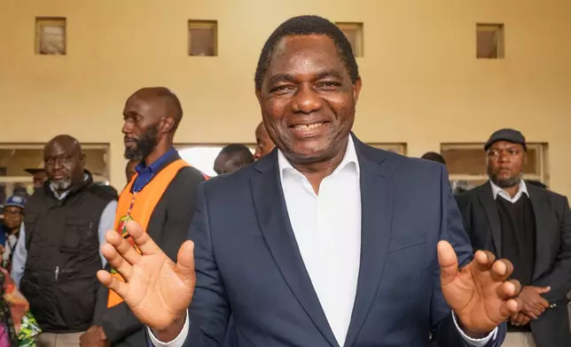 Zambia's President Hakainde Hichilema shares a light moment with journalists after casting his vote at a polling station in Lusaka, Zambia, Thursday, Aug. 13, 2026. (AP Photo/Anita Reed)