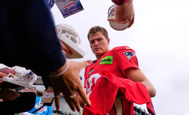 New England Patriots quarterback Drake Maye signs autographs after the team's NFL football training camp, Thursday, July 30, 2026, in Foxborough, Mass. (AP Photo/Charles Krupa)