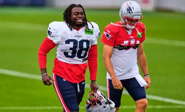 New England Patriots running back Rhamondre Stevenson (38) heads to a practice field with Drake Maye during the team's NFL football training camp, Thursday, July 30, 2026, in Foxborough, Mass. (AP Photo/Charles Krupa)
