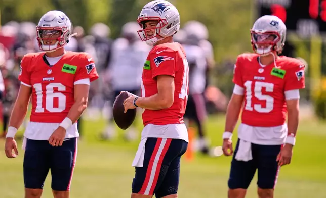 New England Patriots quarterback Drake Maye, center, practices with quarterbacks Tommy DeVito (16) and Behren Morton (15) during the team's NFL football training camp, Friday, July 31, 2026, in Foxborough, Mass. (AP Photo/Charles Krupa)