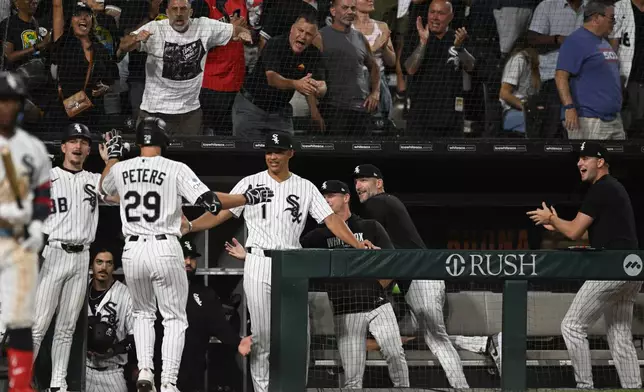 Chicago White Sox's Tristan Peters (29) celebrates with manager Will Venable (1) at the dugout after hitting a two-run home during the fifth inning of a baseball game against the Texas Rangers in Chicago, Wednesday, Aug. 26, 2026. (AP Photo/Paul Beaty)