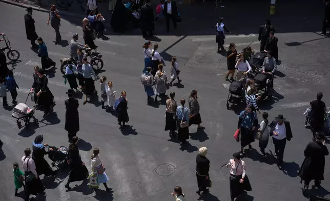 Ultra-Orthodox Jews cross a street in the Mea Shearim neighborhood of Jerusalem, Tuesday, Aug. 18, 2026. (AP Photo/Ohad Zwigenberg)