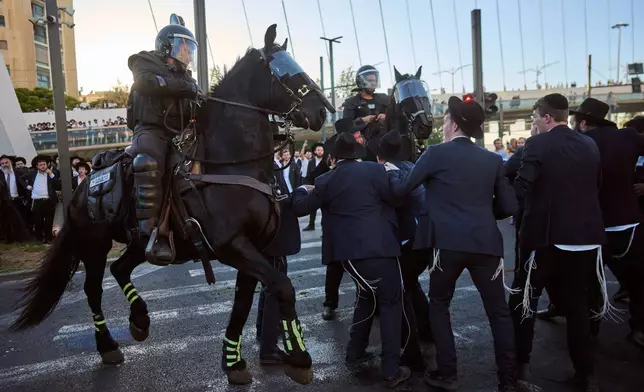 Israeli mounted police disperse Ultra-Orthodox Jews blocking a road during a protest against the army draft in Jerusalem, Monday, June 1, 2026. (AP Photo/Ohad Zwigenberg)