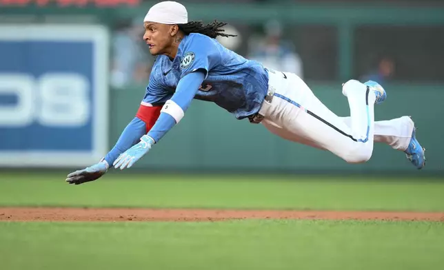 Washington Nationals' CJ Abrams dives towards second base for a double during the third inning of a baseball game against the Cincinnati Reds, Saturday, Aug. 8, 2026, in Washington. (AP Photo/Nick Wass)