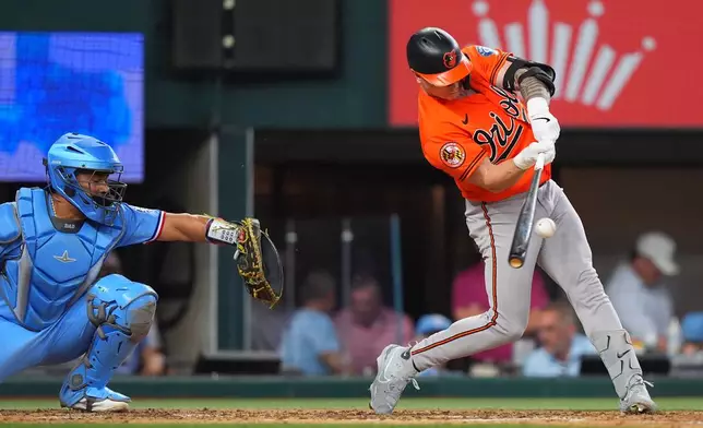 Baltimore Orioles' Tyler O'Neill, right, hits a two run homer in front of Texas Rangers catcher Elias Díaz during the fifth inning of a baseball game, Sunday, Aug. 9, 2026, in Arlington, Texas. (AP Photo/LM Otero)