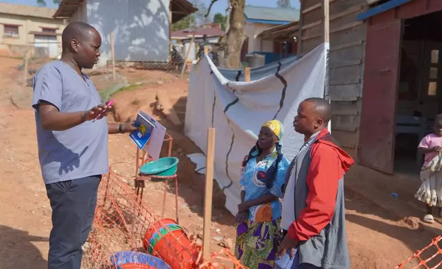 Gédéon Banga Ngbape, left, an Ebola surveillance officer, does contact tracing in Nizi, Ituri province, eastern Congo, Friday, Aug. 14, 2026. (AP Photo/Dieudonne Dirole)