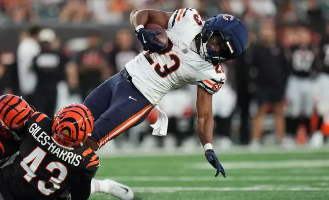 Chicago Bears running back Roschon Johnson (23) falls as he's tackled on a first down by Cincinnati Bengals linebacker Joe Giles-Harris (43) and Bengals safety Russ Yeast during the first half of a preseason NFL football game Saturday, Aug. 22, 2026, in Cincinnati. (AP Photo/Joshua A. Bickel)