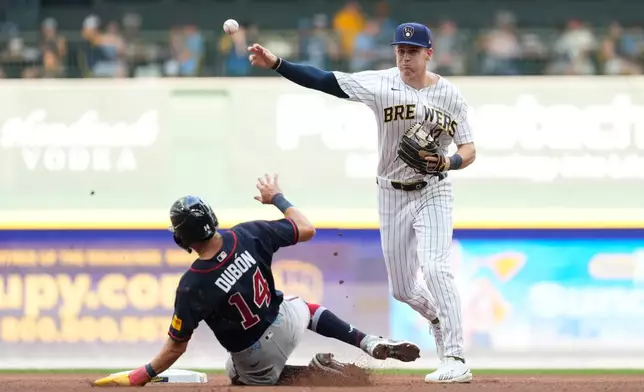 Milwaukee Brewers' Cooper Pratt, right, turns a double play after forcing out Atlanta Braves' Mauricio Dubón (14) at second during the fourth inning of a baseball game Saturday, Aug. 22, 2026, in Milwaukee. (AP Photo/Aaron Gash)
