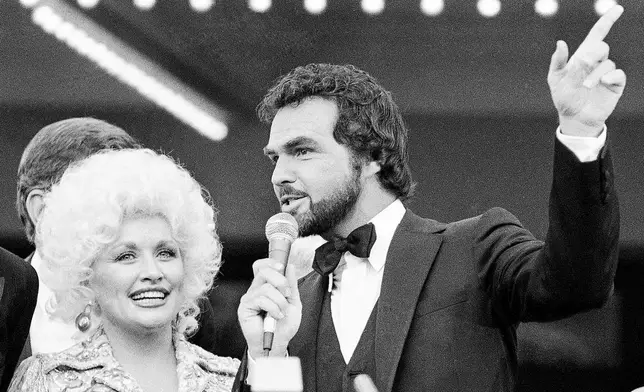 FILE - Dolly Parton, left, and Burt Reynolds appear at the premier of their film "The Best little Whorehouse in Texas" in Austin, on July 12, 1982. (AP Photo/Ted Powers, File)