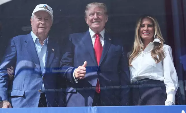 Roger Penske, President Donald Trump and first lady Melania Trump watch after Kyle Kirkwood (27) won the IndyCar Freedom 250 Grand Prix auto race in Washington, Sunday, Aug. 23, 2026. (AP Photo/Alex Brandon)