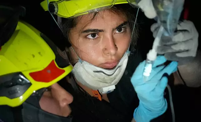 Rescue workers prepare an IV for a survivor pulled from the rubble the day after an earthquake struck Pereira, Colombia, Tuesday, Aug. 11, 2026. (AP Photo/Fernando Vergara)