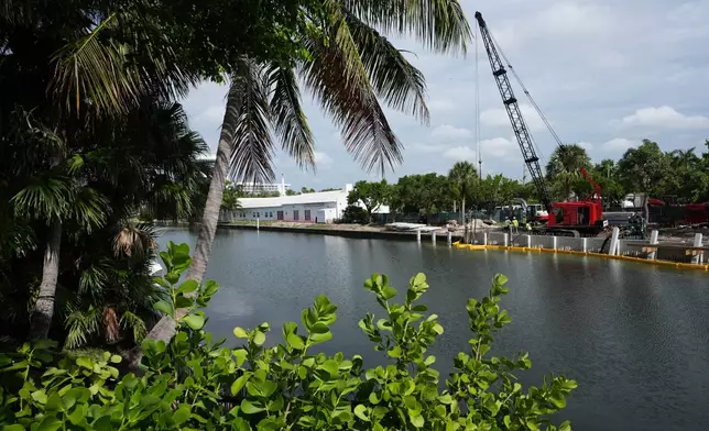 Workers install a 3D-printed living seawall manufactured by Kind Designs at the Church by the Sea, Tuesday, Aug. 4, 2026, in Fort Lauderdale, Fla. (AP Photo/Lynne Sladky)