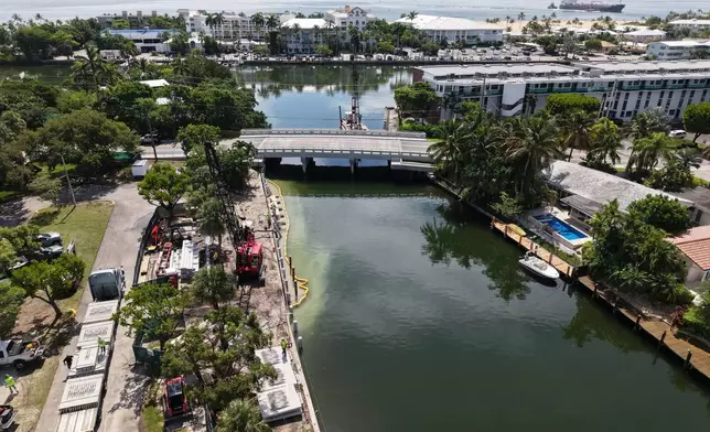 Workers install a 3D-printed living seawall manufactured by Kind Designs at the Church by the Sea, Tuesday, Aug. 4, 2026, in Fort Lauderdale, Fla. (AP Photo/Lynne Sladky)